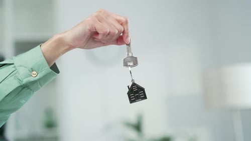 Hand Holding Key With House Keychain