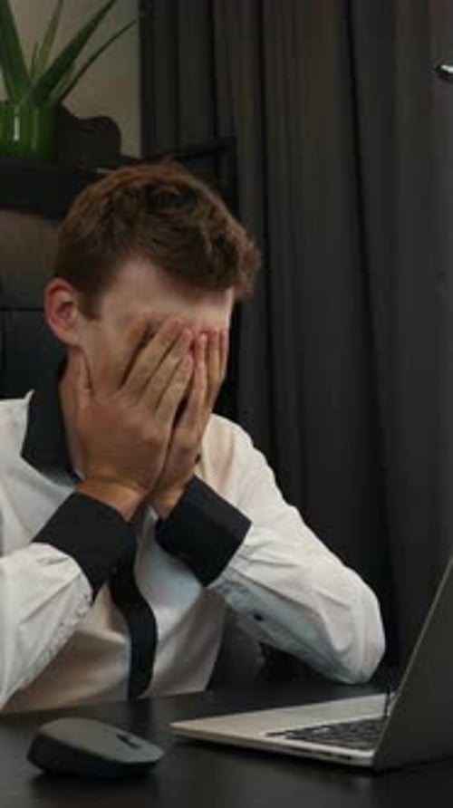 Frustrated Young Adult Typing on Computer at Desk