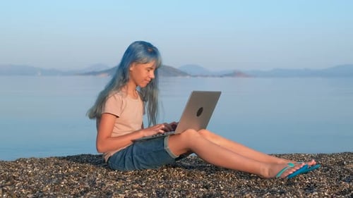 Girl with Laptop on Pebbles Beach