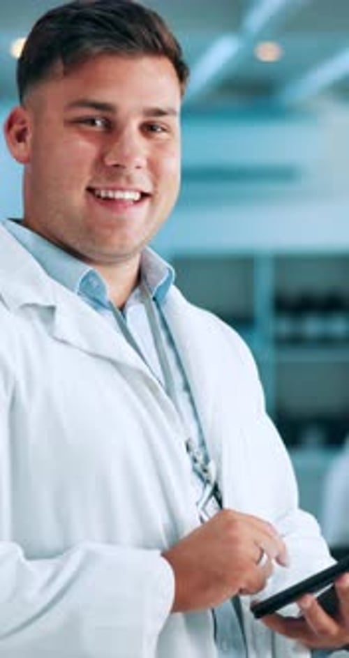 Smiling Man in Lab Coat Holding Mobile Device