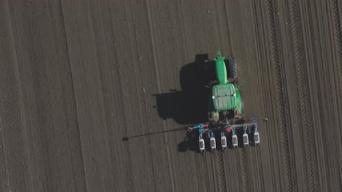 The tractor plows the field