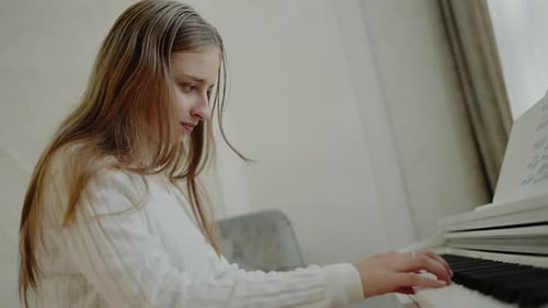 Young Woman Plays Piano in Bright Room
