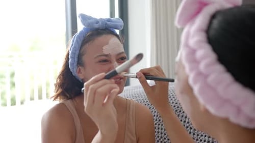 Women Applying Facial Mask Together Indoors