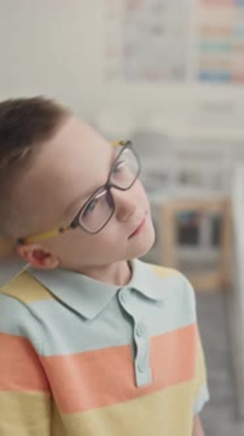 Young Boy with Glasses Looking Around Indoors