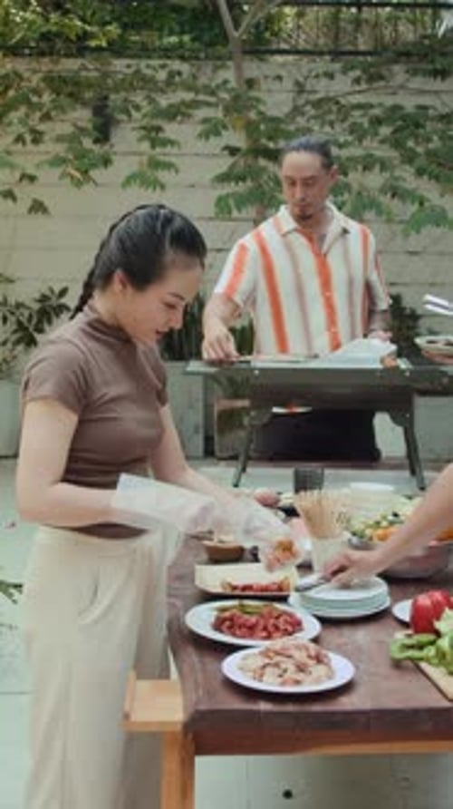 Young Adults Grilling Meat Outdoors in Urban Setting