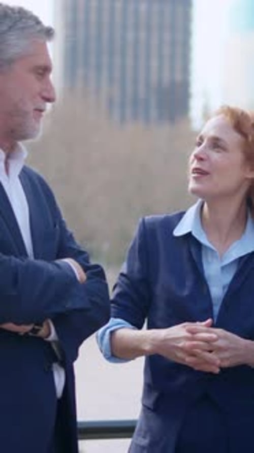 Mature Boss Talking with a Team of Business People Outdoors