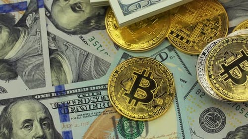 Bitcoin coins and one hundred dollar bills