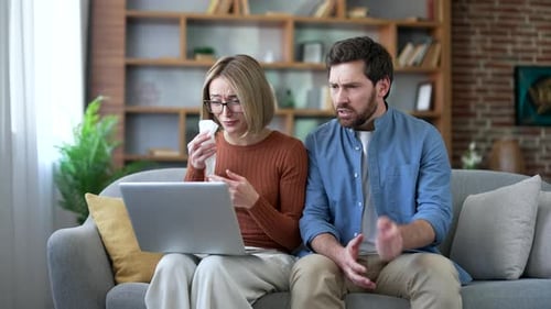 Sad married couple talking on video call with family psychologist using laptop sitting at home.