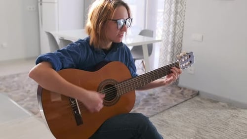Young Woman Plays Guitar in Bright Home