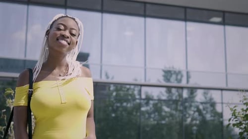 Woman Smiles While Walking By Building