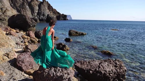 Side View a Young Beautiful Sensual Woman with Black Hair in a Long Mint Dress Posing on a Beach