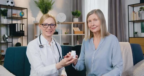 Médecin et patient assis devant la caméra avec un sourire sincère et tenant une bouteille de vitamines