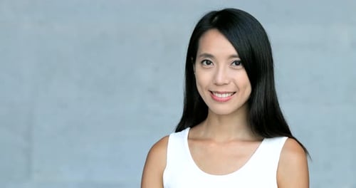 Asian young woman smile to camera over grey background