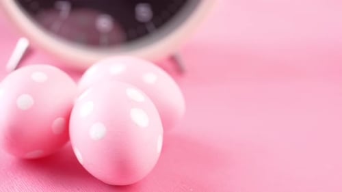 Easter Concept with Egg and a Clock on Pink Background