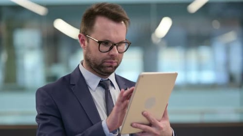 Man in Suit Using Tablet in Office