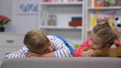 Children Lying on Sofa with Teddy Bear