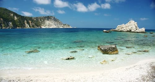 Peaceful White Beach with Pebbles Seascape with Rocks in Background
