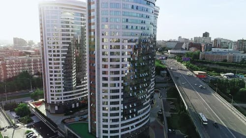 Überführung durch moderne Bürogebäude bei Sonnenuntergang. Überqueren von Straßen im Zentrum einer Großstadt. Blendung durch Sonne.