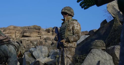 Armed Soldiers Standing Guard on Rocky Terrain