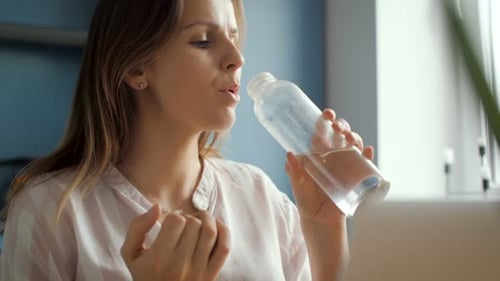 Mädchen trinkt Wasser aus Glasflasche