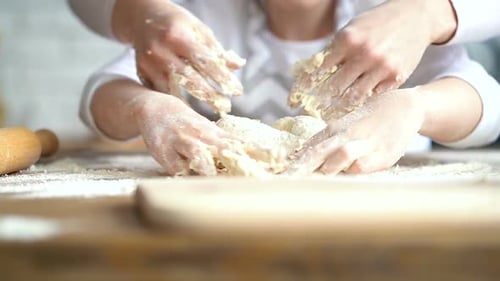 Mutter und Tochter kneten Teig auf dem Küchentisch