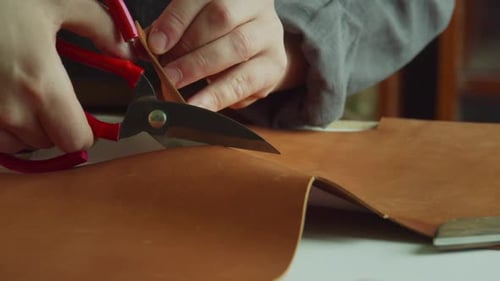Close-up Slow Motion Tailor's Scissors Make an Incision in a Piece of Genuine Leather in the Process