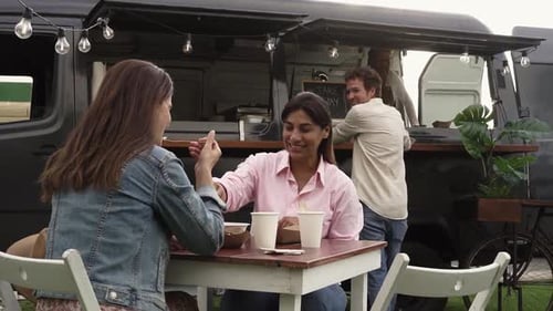 Gente multirracial feliz disfrutando de comida en un mercado callejero de camiones de comida