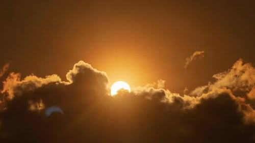 Fiery Sunrise Illuminates Thick Clouds in Golden Sky