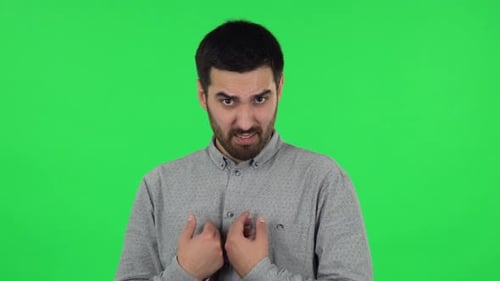 Portrait d'un mec brun se pointe innocente, dit qui moi, lui tord le doigt