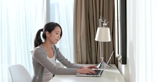 Woman Stretches at Desk While Using Laptop