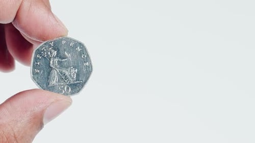 Fingers Hold A Uk 50 Pence Coin Back