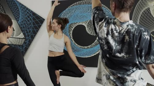 Millennials Practicing Yoga in Modern Loft Studio