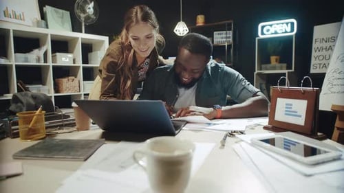 Smiling Businesswoman Helping African American Man Worked at Laptop in Office.