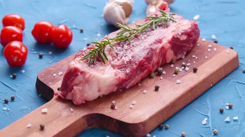 Uncooked Steak Garnished on Cutting Board Close Up