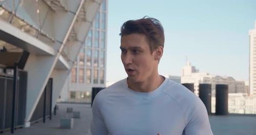 Man Running Toward Camera on Urban Rooftop