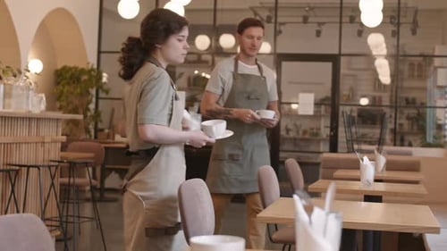 Two Waiters Setting Tables in Cafe
