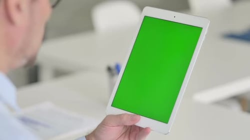 Middle Aged Man Using Tablet with Green Chroma Screen