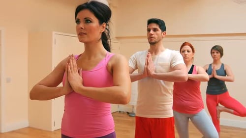 Yoga Class with Adults Practicing Poses Indoors
