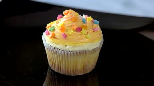 Cupcake with Yellow Frosting and Flower Sprinkles