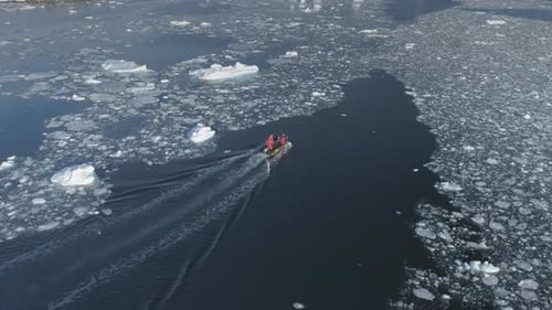 Boat navigates icy waters in frigid, arctic landscape