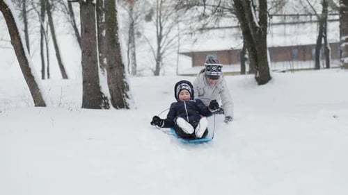 Kinder haben Spaß mit Schlitten auf Snowy Hill