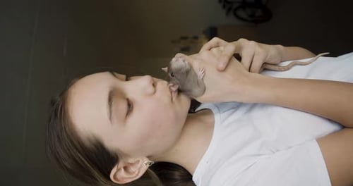 Woman Cuddling a Pet Rat Indoors