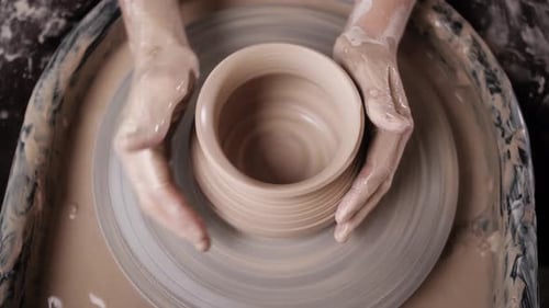 Homme potier travaillant sur le tour de potier fabriquant un pot en céramique à partir d'argile dans un atelier de poterie