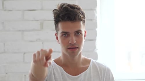 Man Points at Camera in a Modern Interior