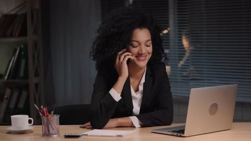 Business Woman Working on Laptop and Talking Phone