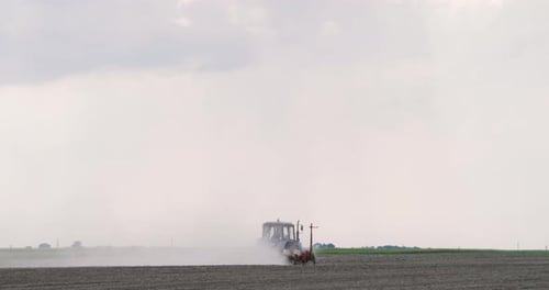 Tractor Plowing Field In Spring Season