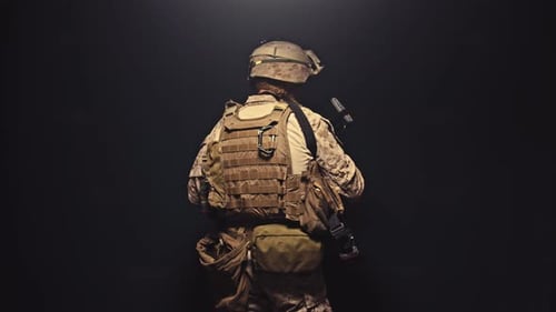 Camouflage Soldier Holds Weapon in Dark Environment