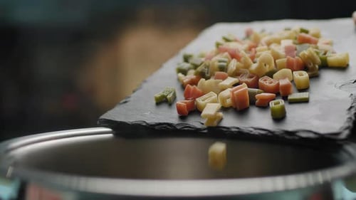 Colorful Alphabet Pasta Falling into a Silver Pot