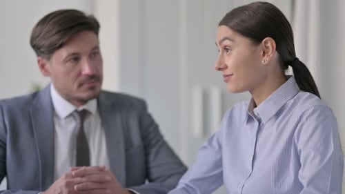 Young Businesswoman Talking to Attractive Middle Aged Businessman