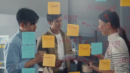 Asia businesspeople stand behind transparent glass wall listen manager pointing progress work.